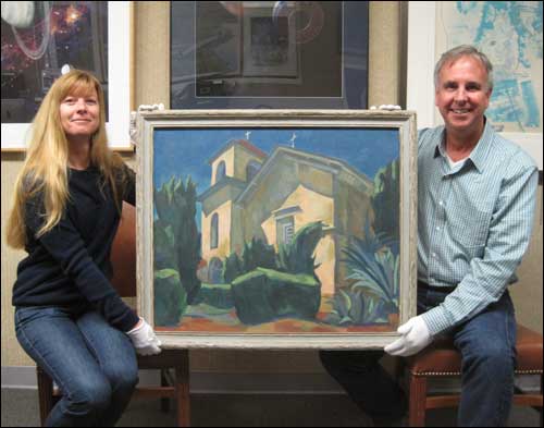Keith Venter and April Gage holding the Gene McComas painting "Mission San Juan Bautista."