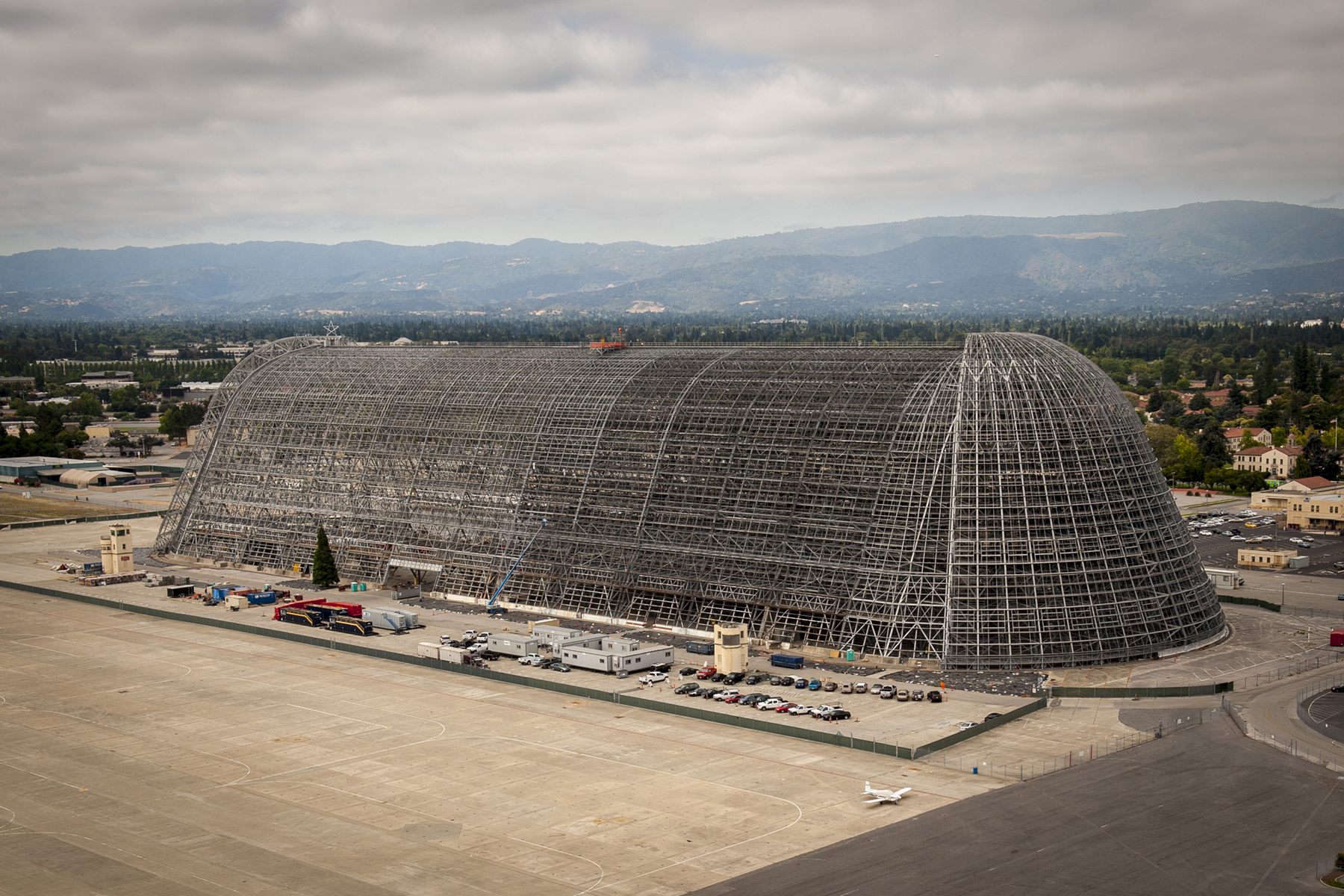 A birds-eye-view of Hangar 1 with all of its exterior metal panels removed and its entire enormous steel structure completely exposed.